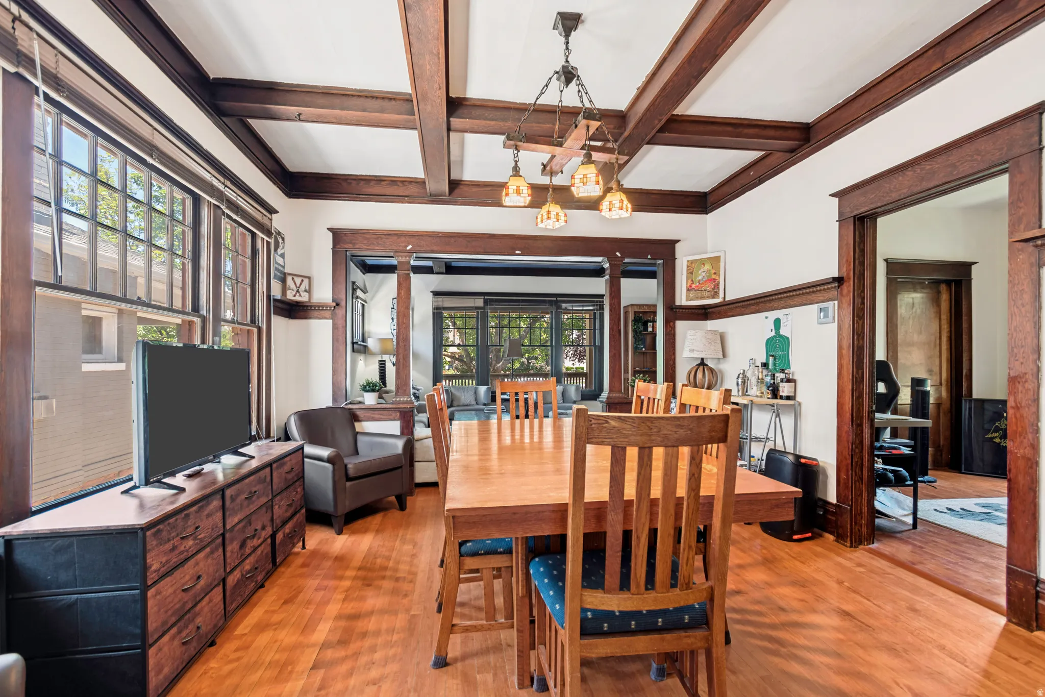 Hardwood flooring throughout featuring dark wood trim and beam ceiling details