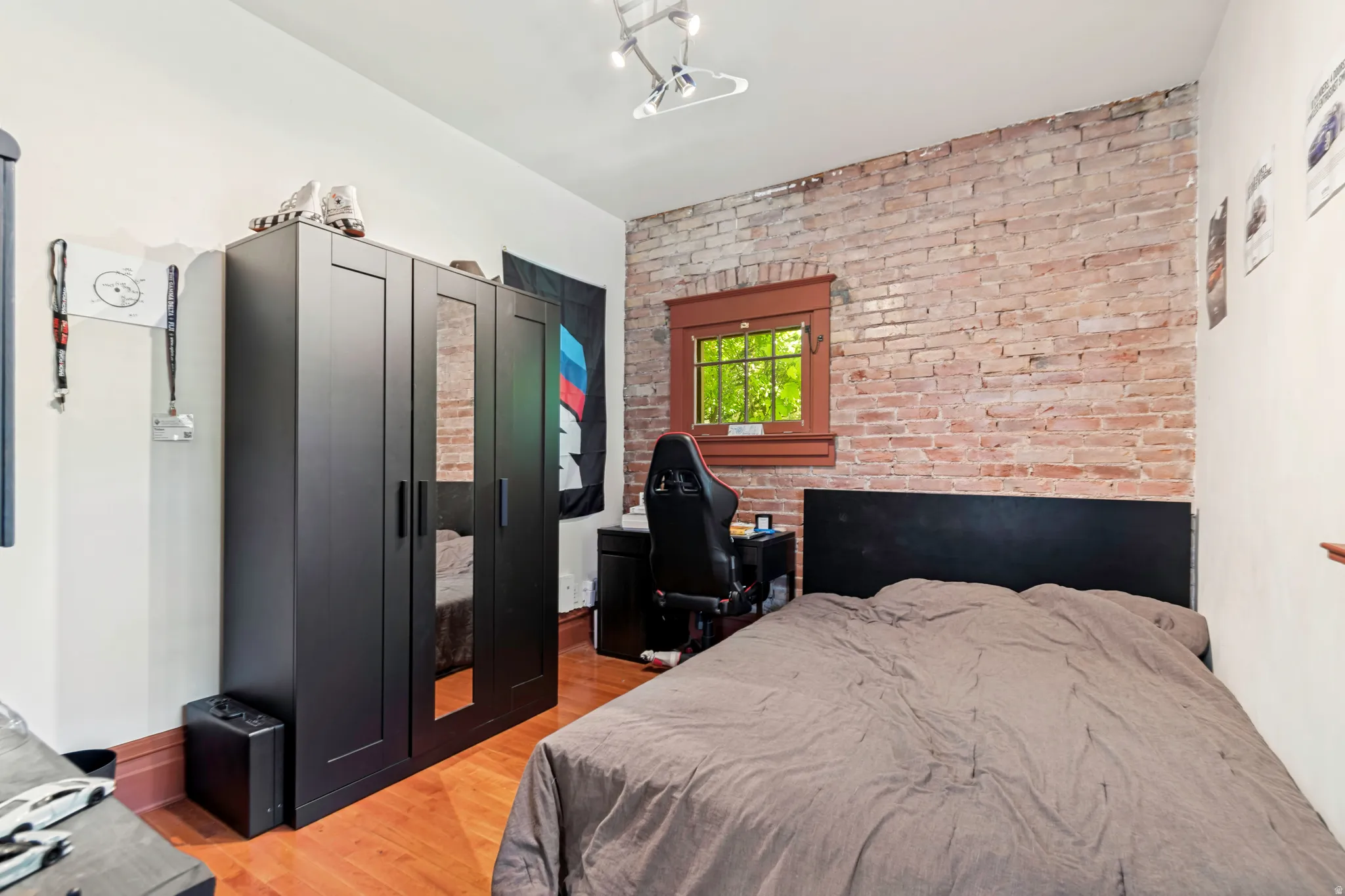 Exposed brick accent wall with a wood-trimmed window