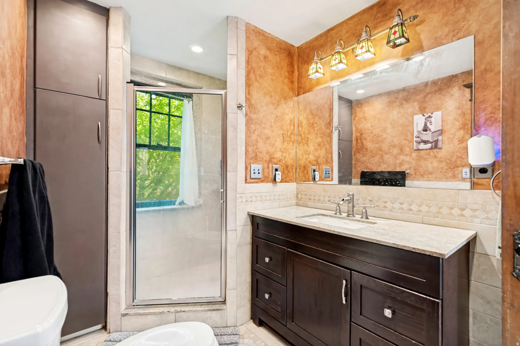 Vanity featuring a light-colored countertop, an undermount sink, and a dark wood-finish cabinet with multiple drawers and doors