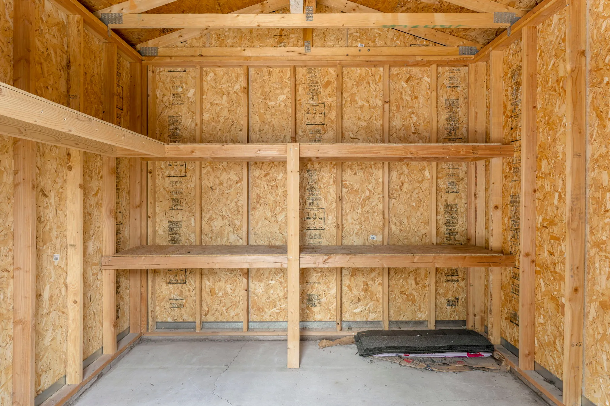 Interior storage structure featuring exposed wood framing and oriented strand board walls
