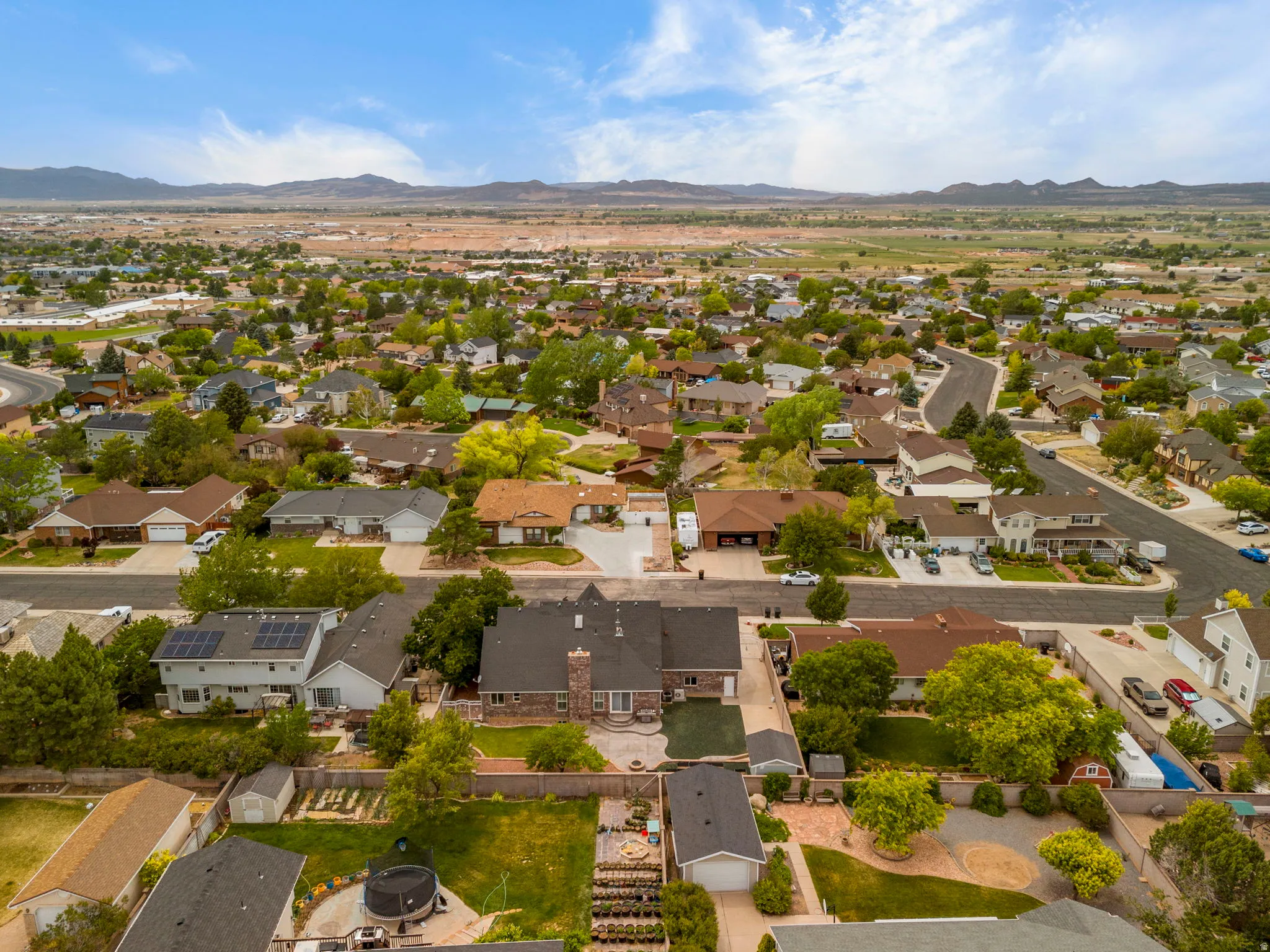 Aerial perspective showcasing a residential neighborhood with diverse architectural styles, mature landscaping, and curved street layouts