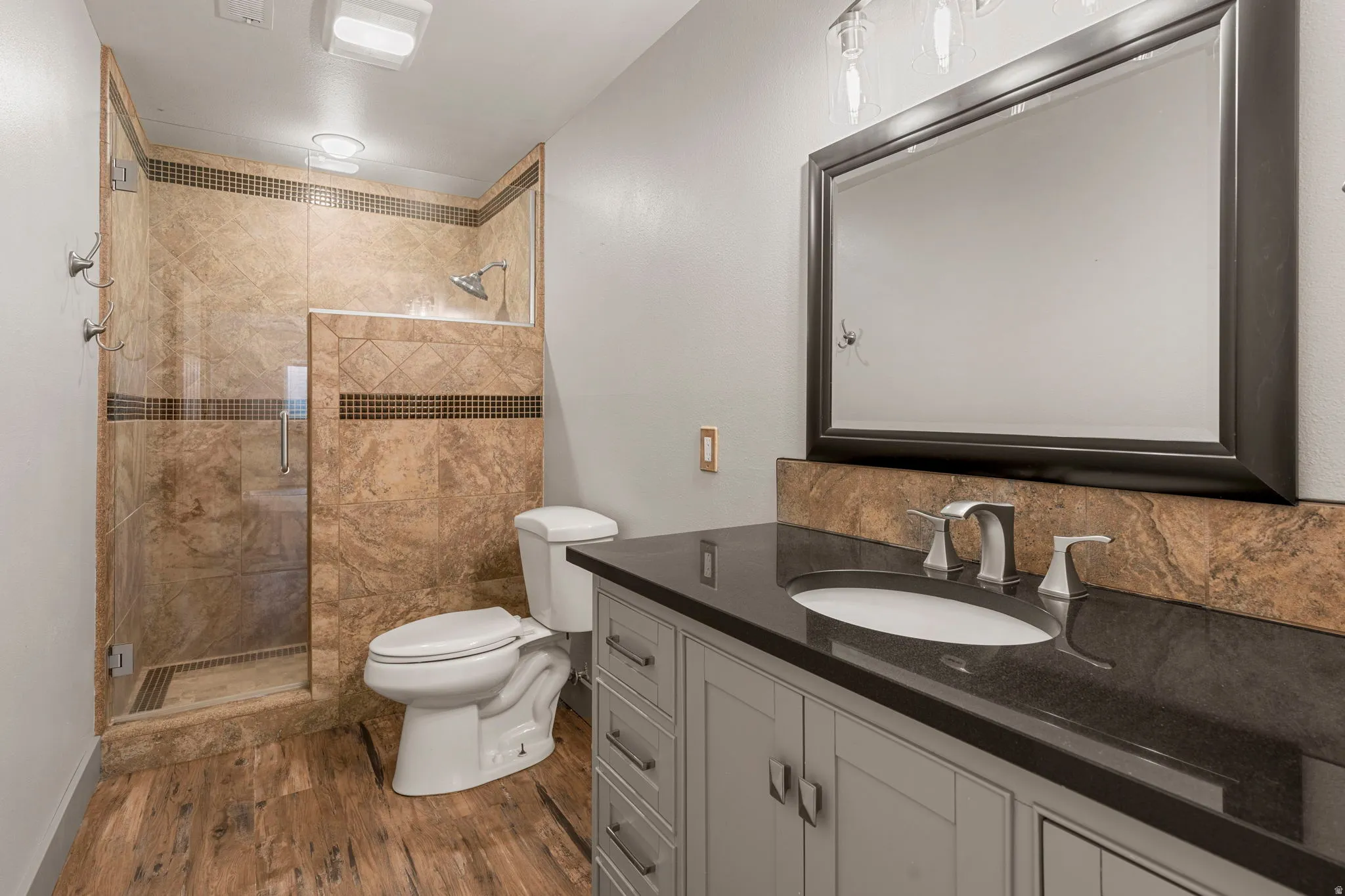 Bathroom featuring a walk-in shower with glass enclosure, tile surround, and built-in shelving
