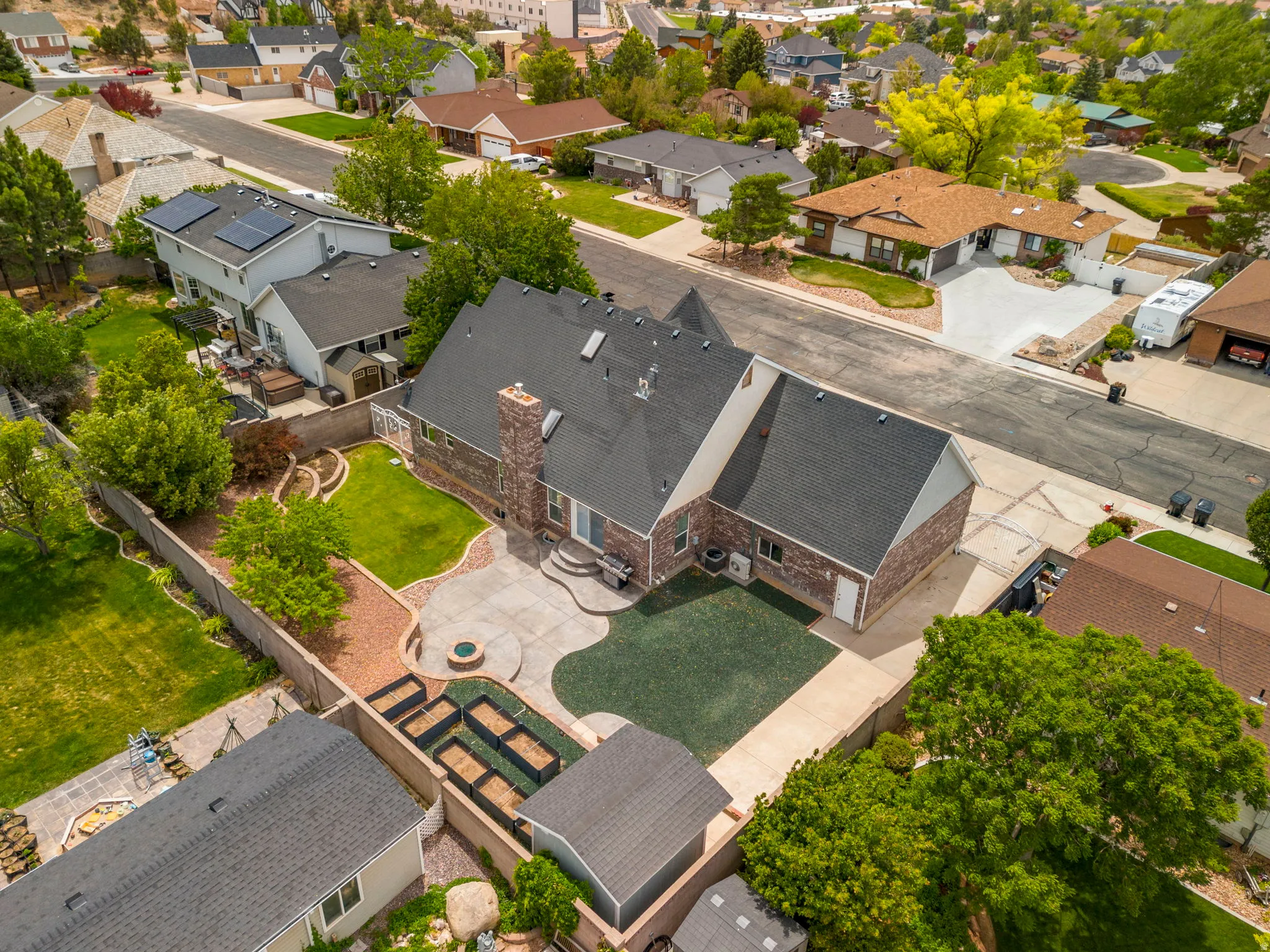 Brick exterior home featuring a dark shingle roof and a spacious backyard
