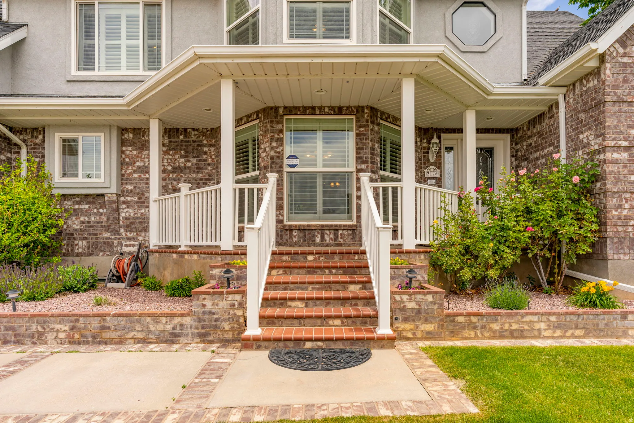Brick and stucco exterior featuring a covered entry porch