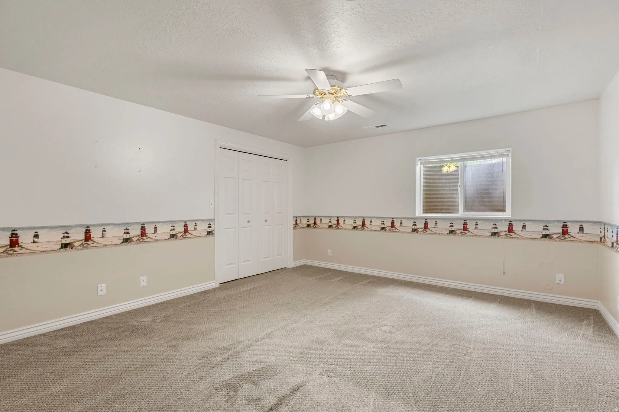 Carpeted room featuring a ceiling fan with integrated lighting, a double bi-fold closet, a window with horizontal blinds, and baseboard trim