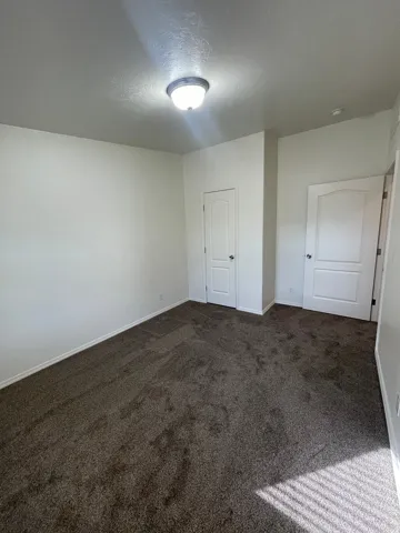 Neutral-toned walls complement the plush carpeting