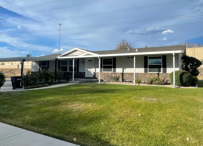 Single-story residence featuring light-colored siding, a covered front entry, and a stone facade