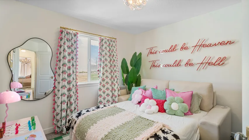 Neutral wall paint, a window with decorative curtains, a decorative wall mirror, and a ceiling-mounted light fixture