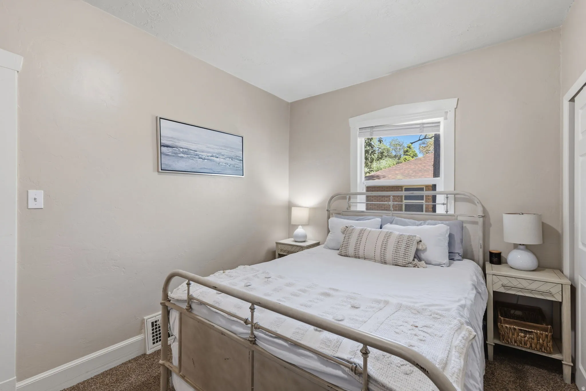 Bedroom featuring neutral wall paint, carpet flooring, a window with white trim, and a white interior door