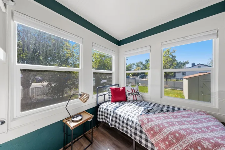Room featuring multiple large windows, wood-finish flooring, white trim, and a beadboard ceiling