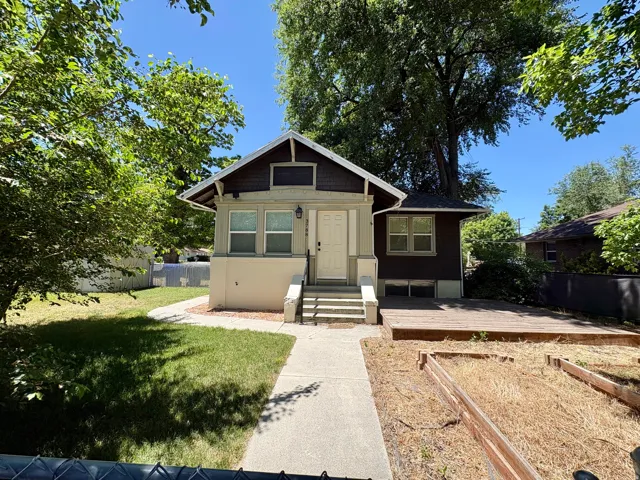 Craftsman-style home featuring a covered front porch with steps, a concrete pathway, and mature trees