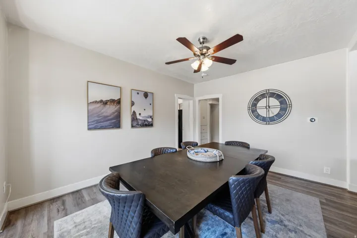 Spacious room featuring wood-finish flooring, light-toned walls, and a ceiling fan with integrated lighting