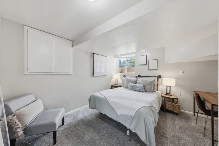 Bedroom featuring light gray walls, gray carpeting, and a window with natural light