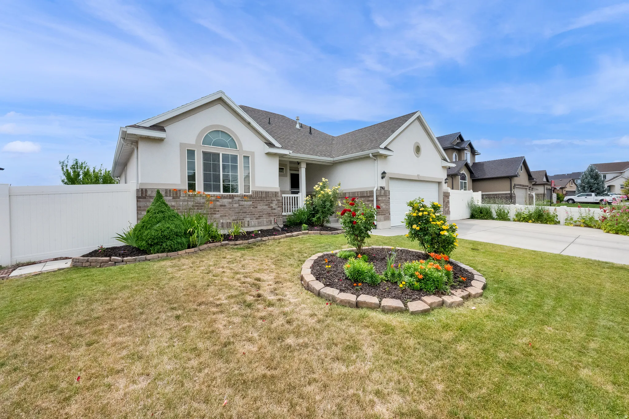 Ranch-style exterior with a partial stone façade, arched window, and attached two-car garage