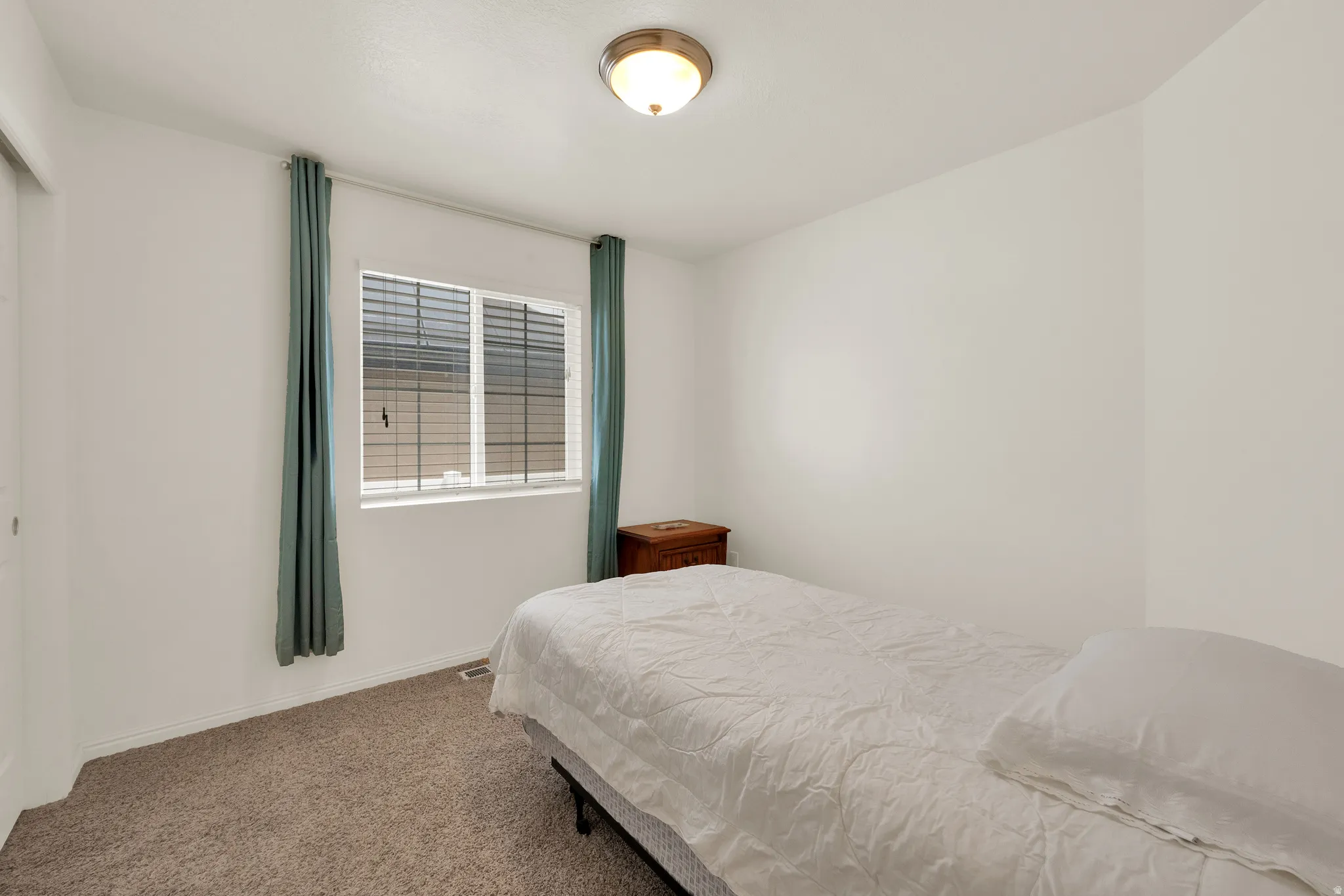 Carpeted room featuring a double-pane window with blinds and white trim, recessed lighting, and white walls