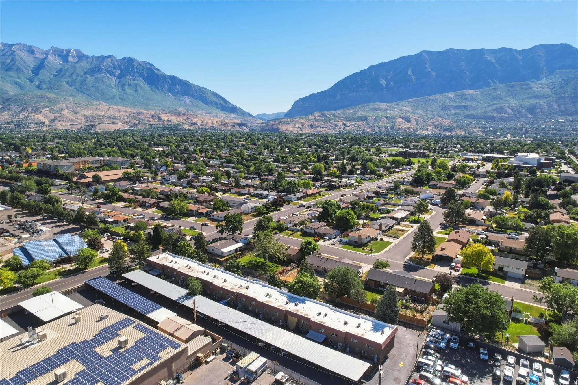 Expansive aerial view showcasing mountainous terrain and a broad residential landscape