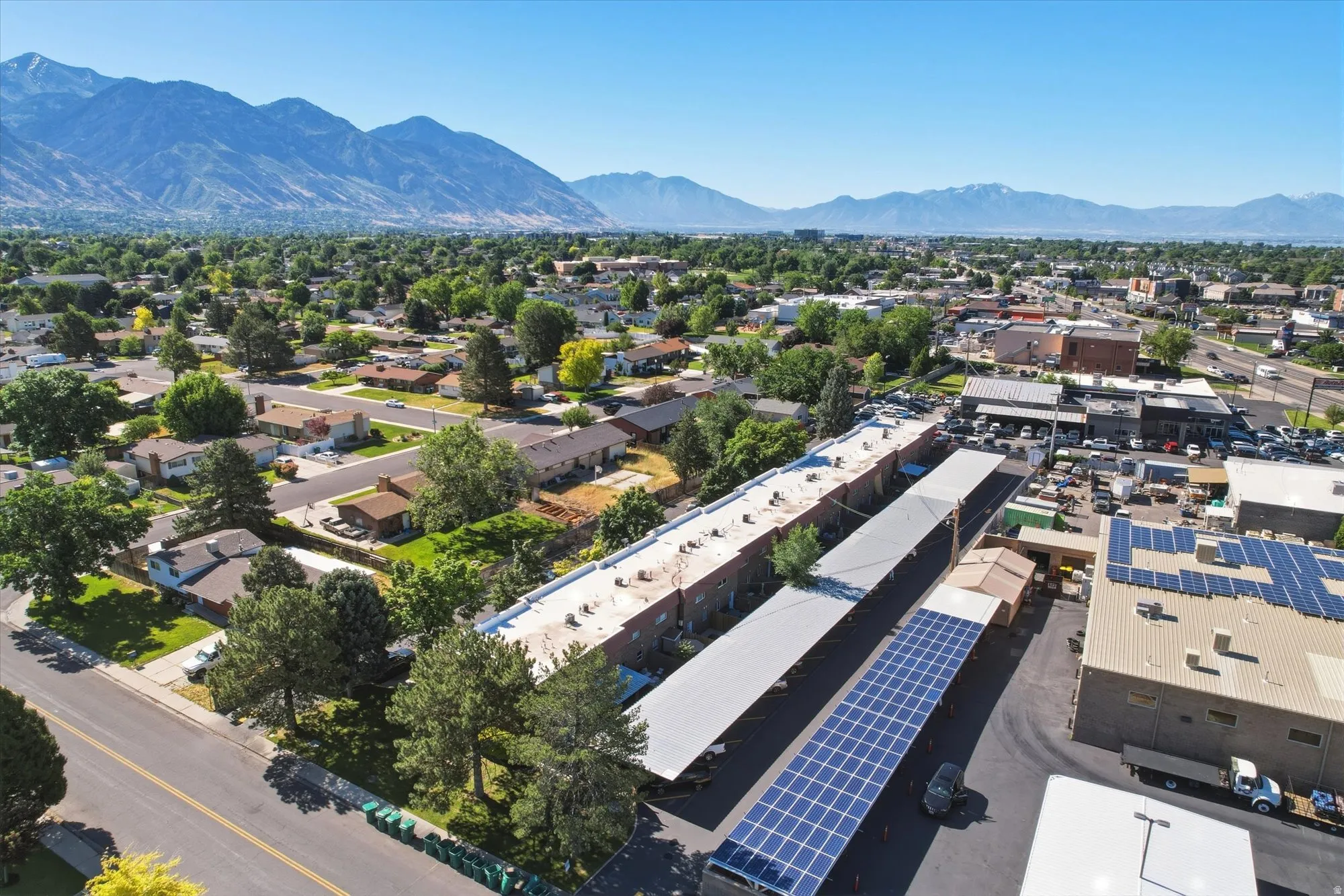 Expansive aerial perspective showcasing a residential area with varied rooflines and established trees