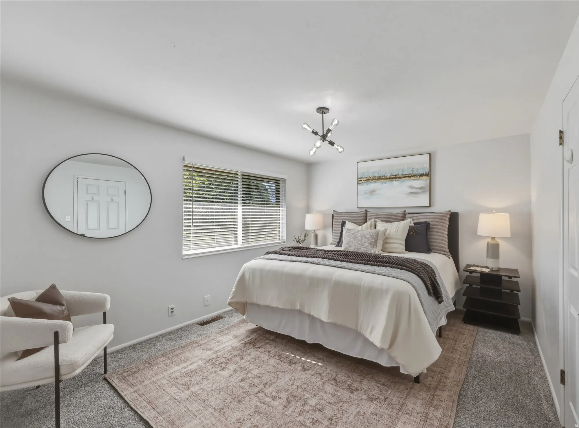Carpeted room with a large window featuring horizontal blinds