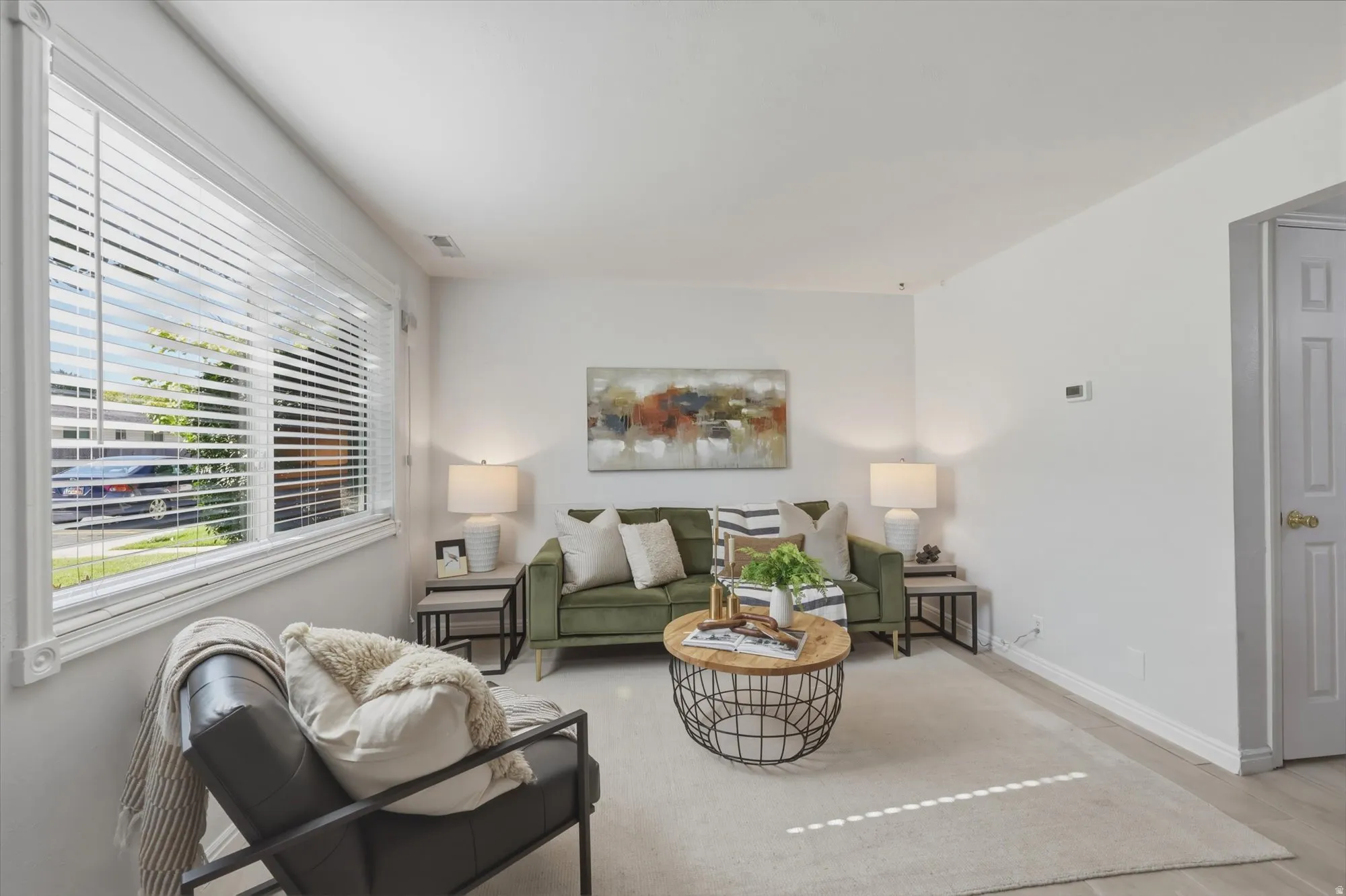 Bright living space featuring large window and white baseboards