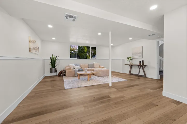 Spacious room with wood-finish flooring, recessed lighting, and a large window
