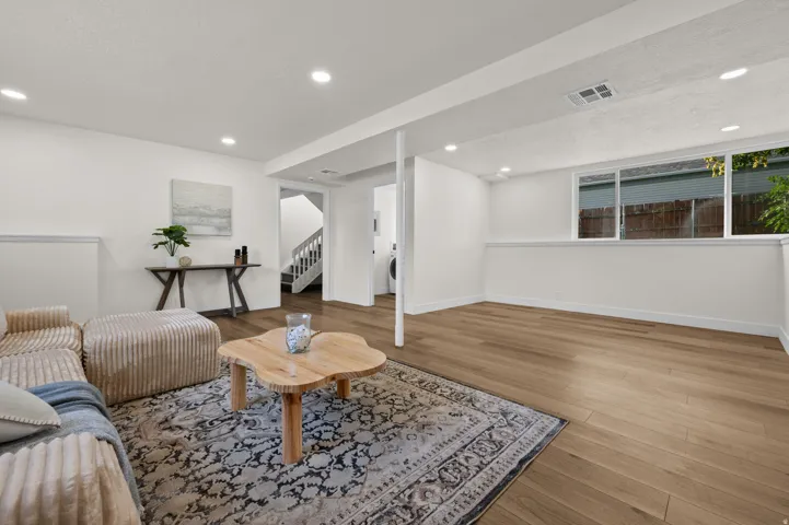 Recessed lighting, wood-finish flooring, white walls, and a large sliding window