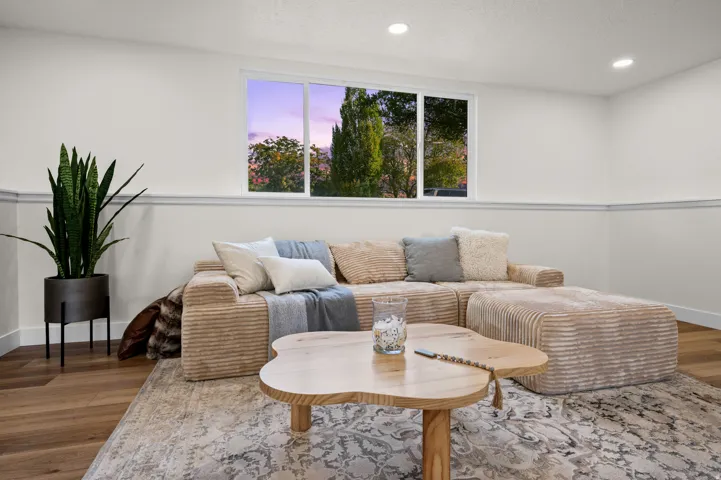 Recessed ceiling lighting, wood-finish flooring, and a large window