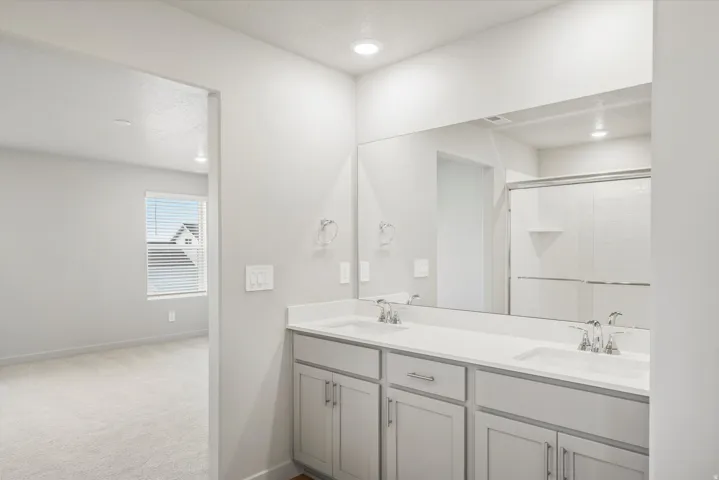 **DISCLAIMER** Interior package may vary. Contemporary bathroom featuring a double vanity with white countertops, chrome fixtures, and light gray cabinetry
