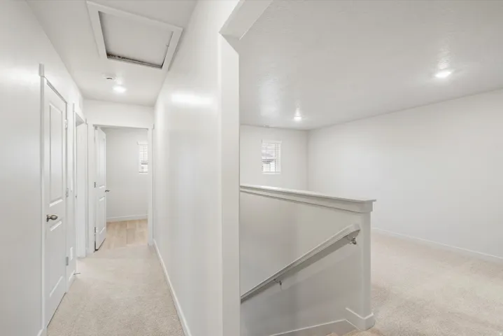 **DISCLAIMER** Interior package may vary. Upper-level hallway and open loft space featuring neutral carpeting, recessed ceiling lighting, a white painted railing, and white painted trim throughout