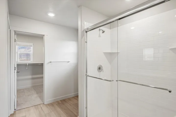 **DISCLAIMER** Interior package may vary. Walk-in shower with clear glass enclosure and white subway tile surround
