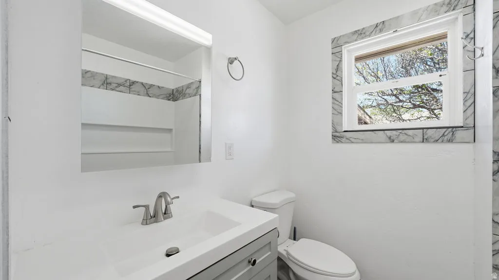 Bathroom vanity with integrated sink, brushed nickel faucet, and a large wall-mounted mirror