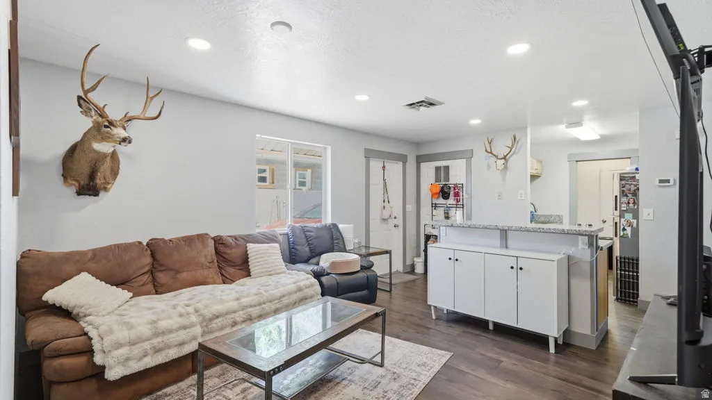 Living space with recessed lighting and wood-finish flooring