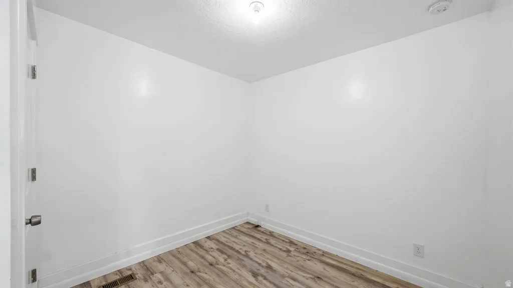 Room featuring light wood-finish flooring, white walls, and white baseboards