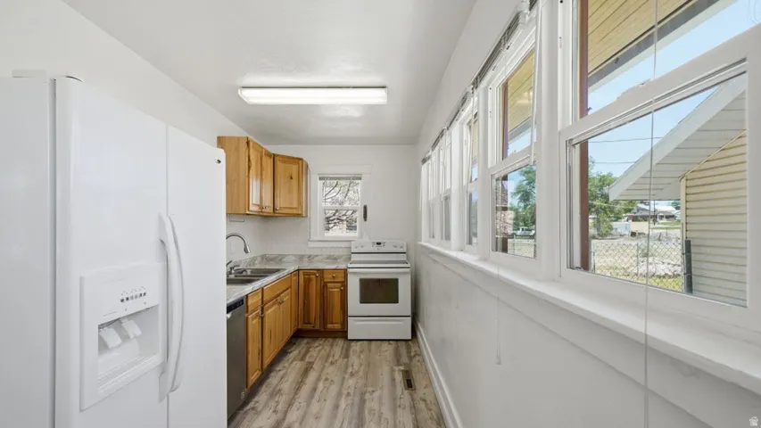 Kitchen featuring wood-finish flooring, wood cabinetry, stone-finish countertops, and a full wall of windows