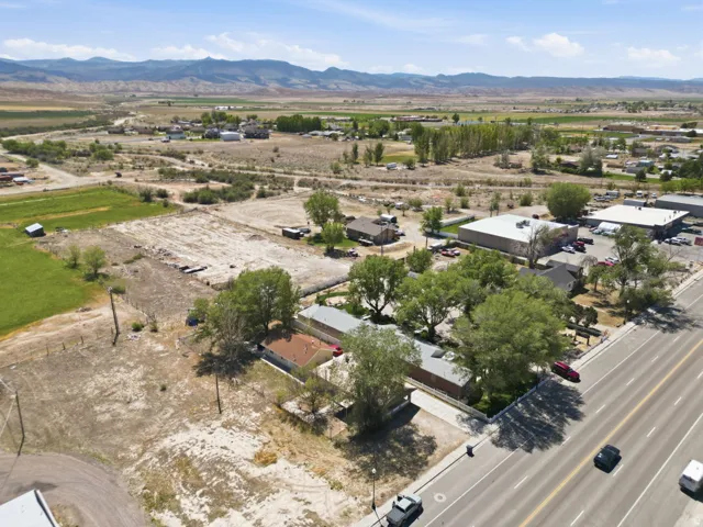 Expansive property featuring a paved road frontage, mature trees, and mountainous scenery