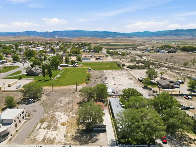 Aerial perspective showcasing expansive land parcels with varying terrain, including green spaces and cleared areas