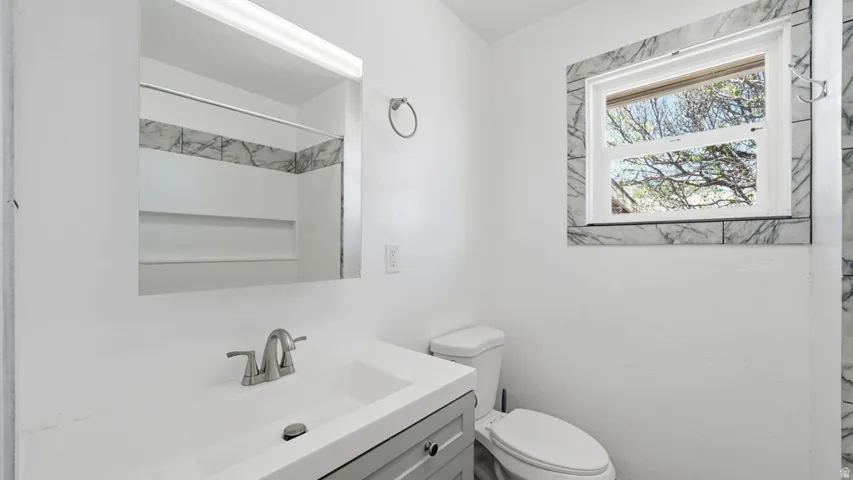 Bathroom vanity with integrated sink, brushed nickel faucet, and a large wall-mounted mirror