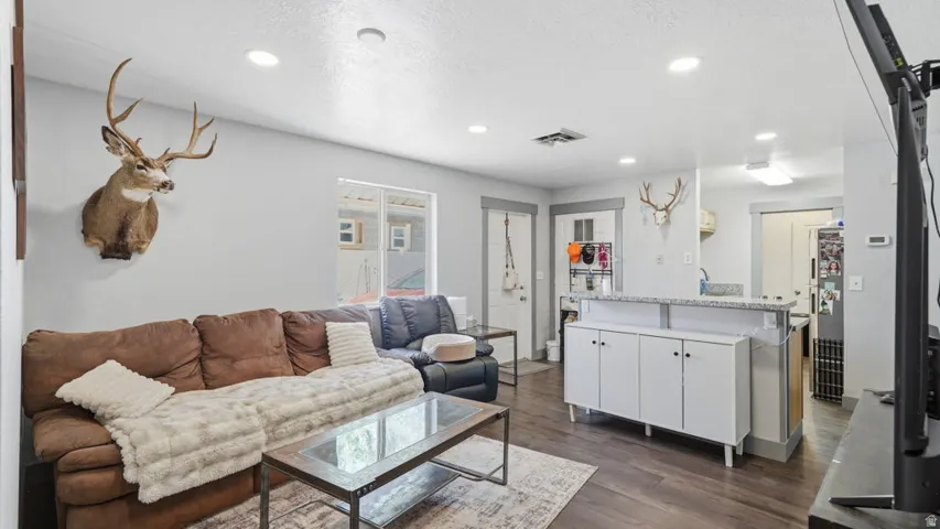 Living space with recessed lighting and wood-finish flooring