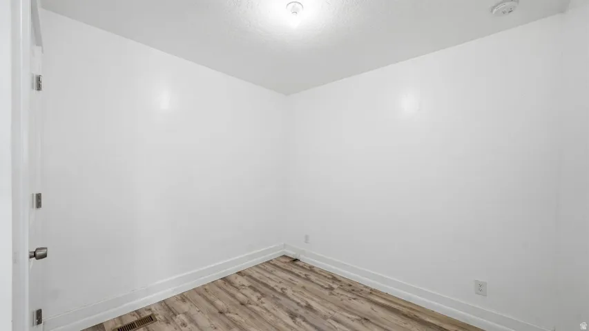 Room featuring light wood-finish flooring, white walls, and white baseboards