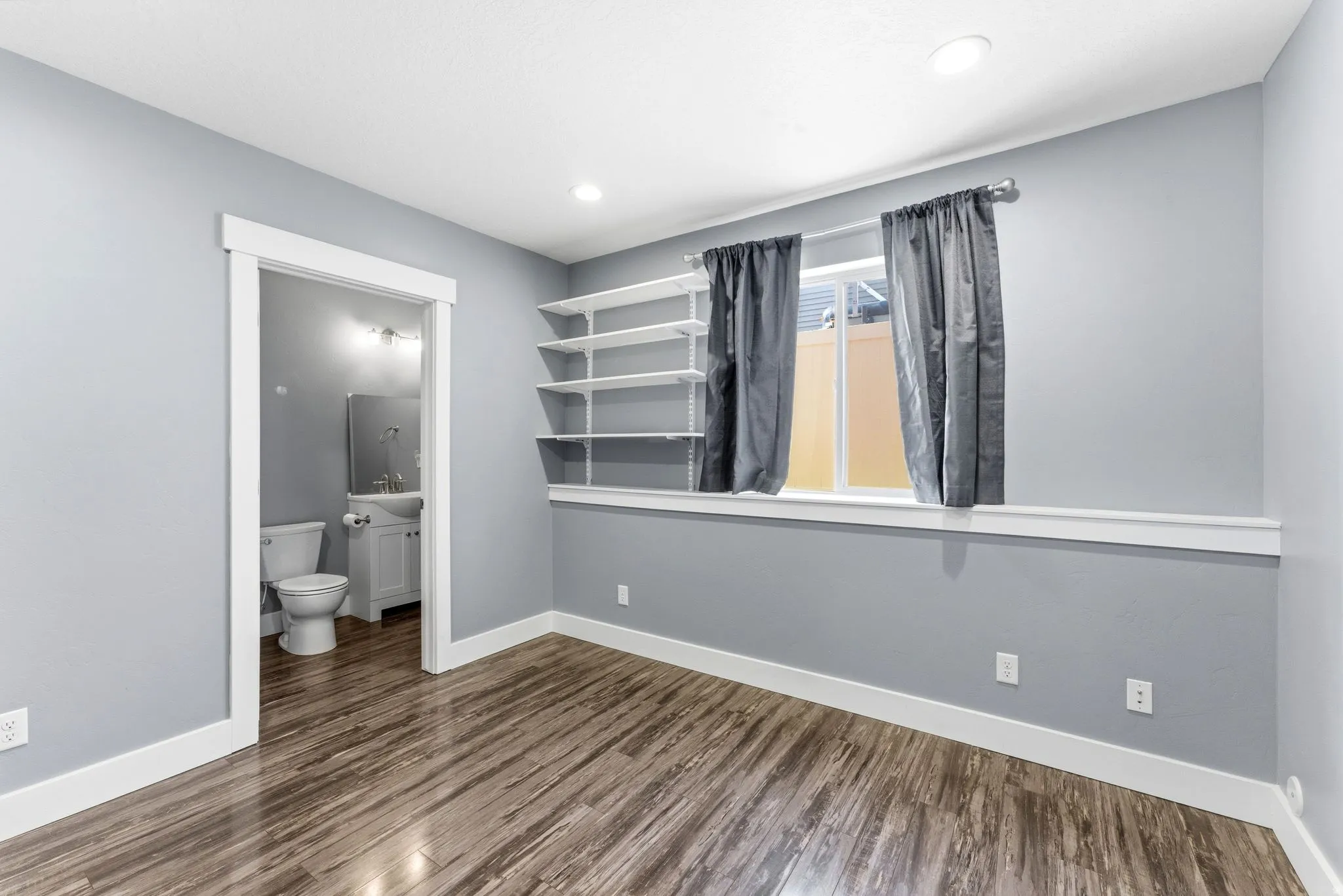 Bedroom 4 featuring wood-finish flooring, recessed lighting, and a window with white trim
