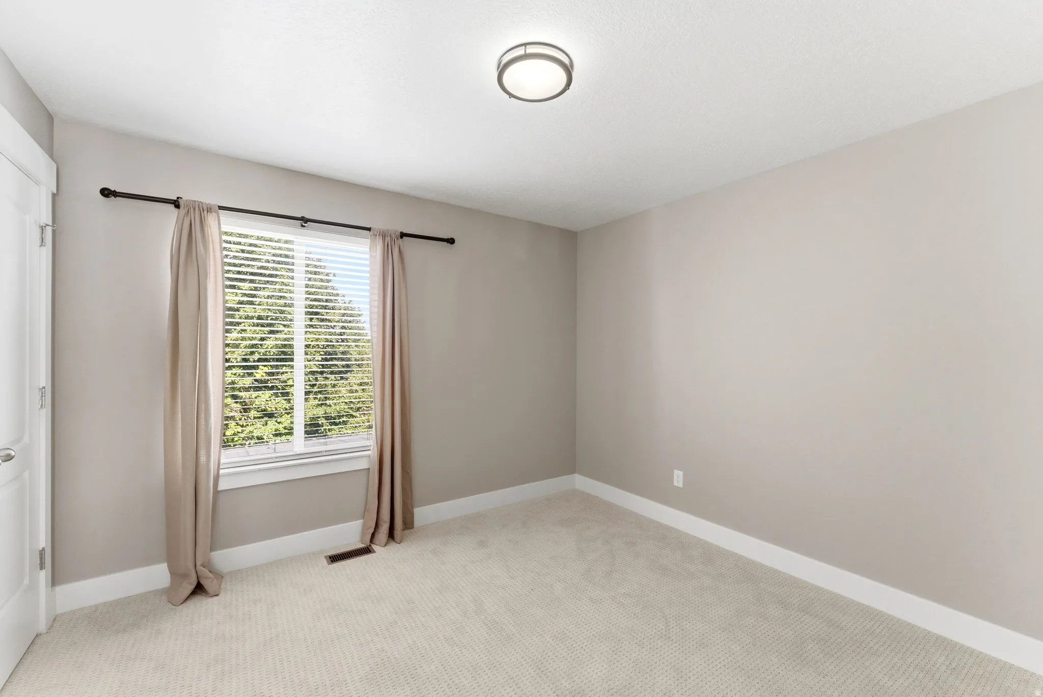 Bedroom 2. Neutral-toned walls and plush, light-colored carpeting define this room