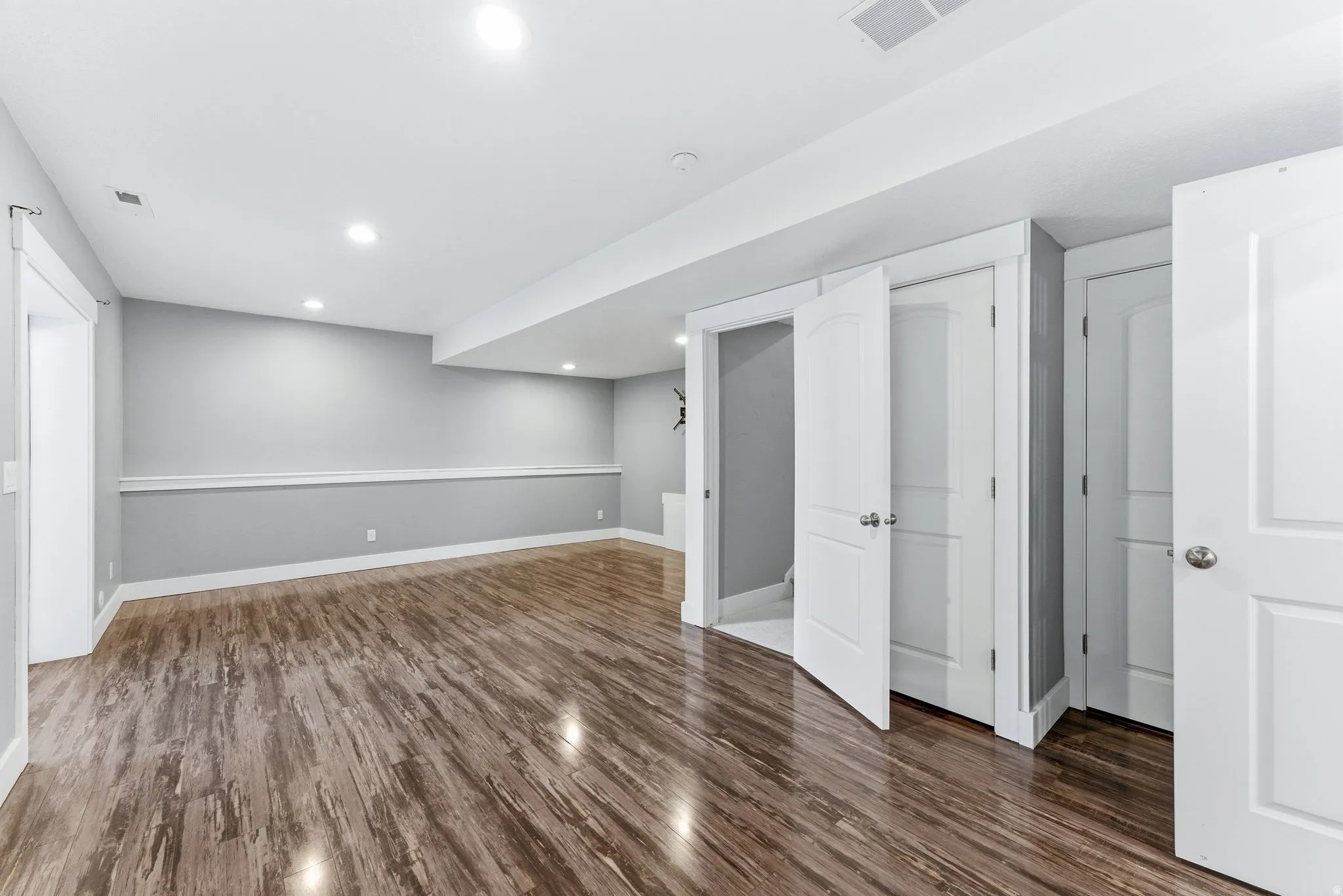 Additional  living room featuring wood-finish flooring, light grey walls with white chair rail molding, and recessed lighting