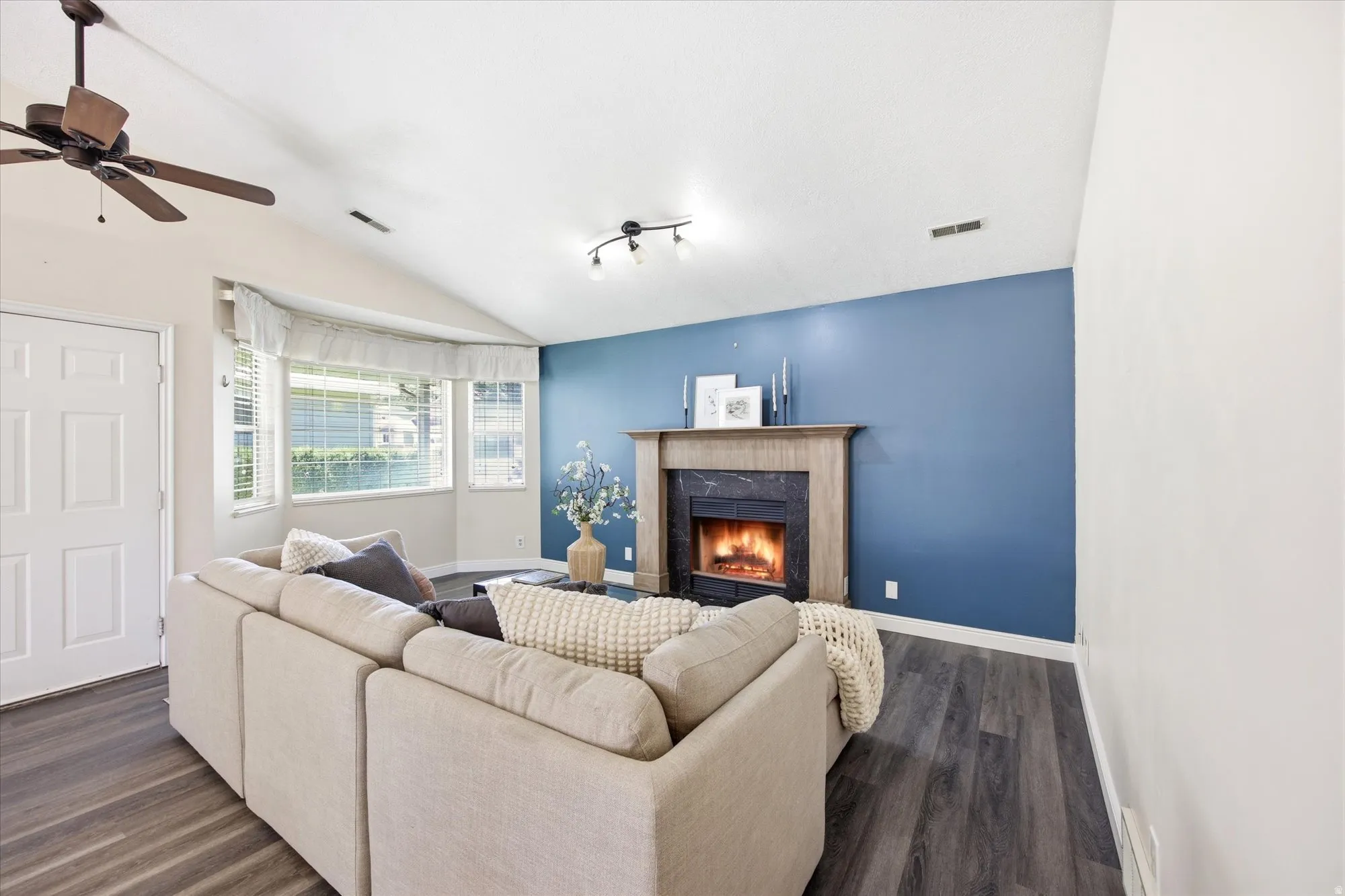 Living area featuring a vaulted ceiling and wood-finish flooring