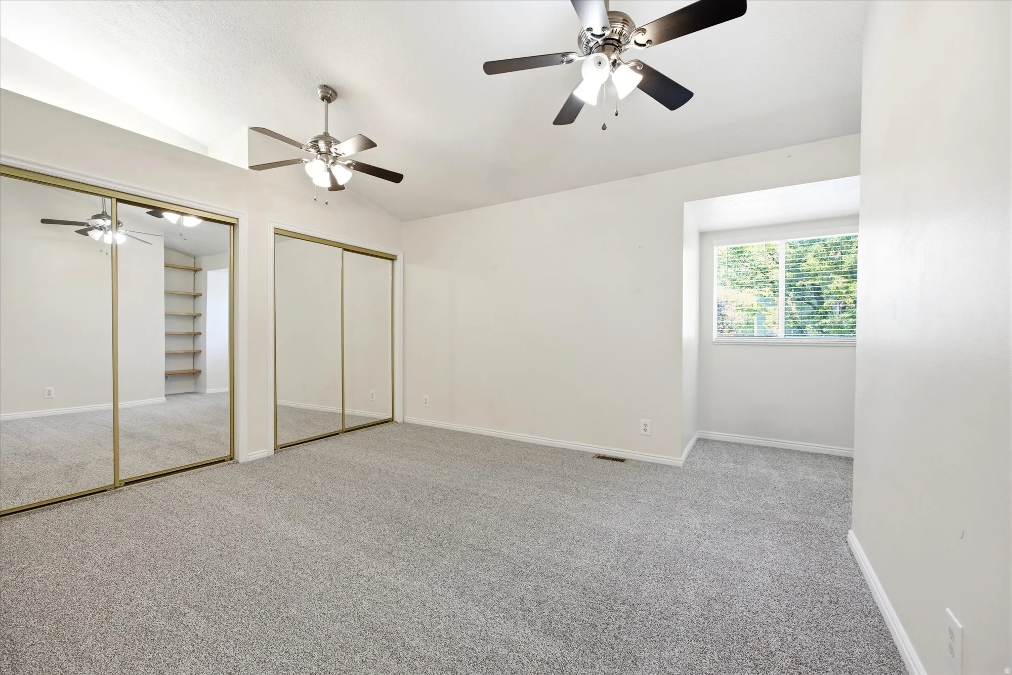 Spacious room featuring light gray carpeting and white walls