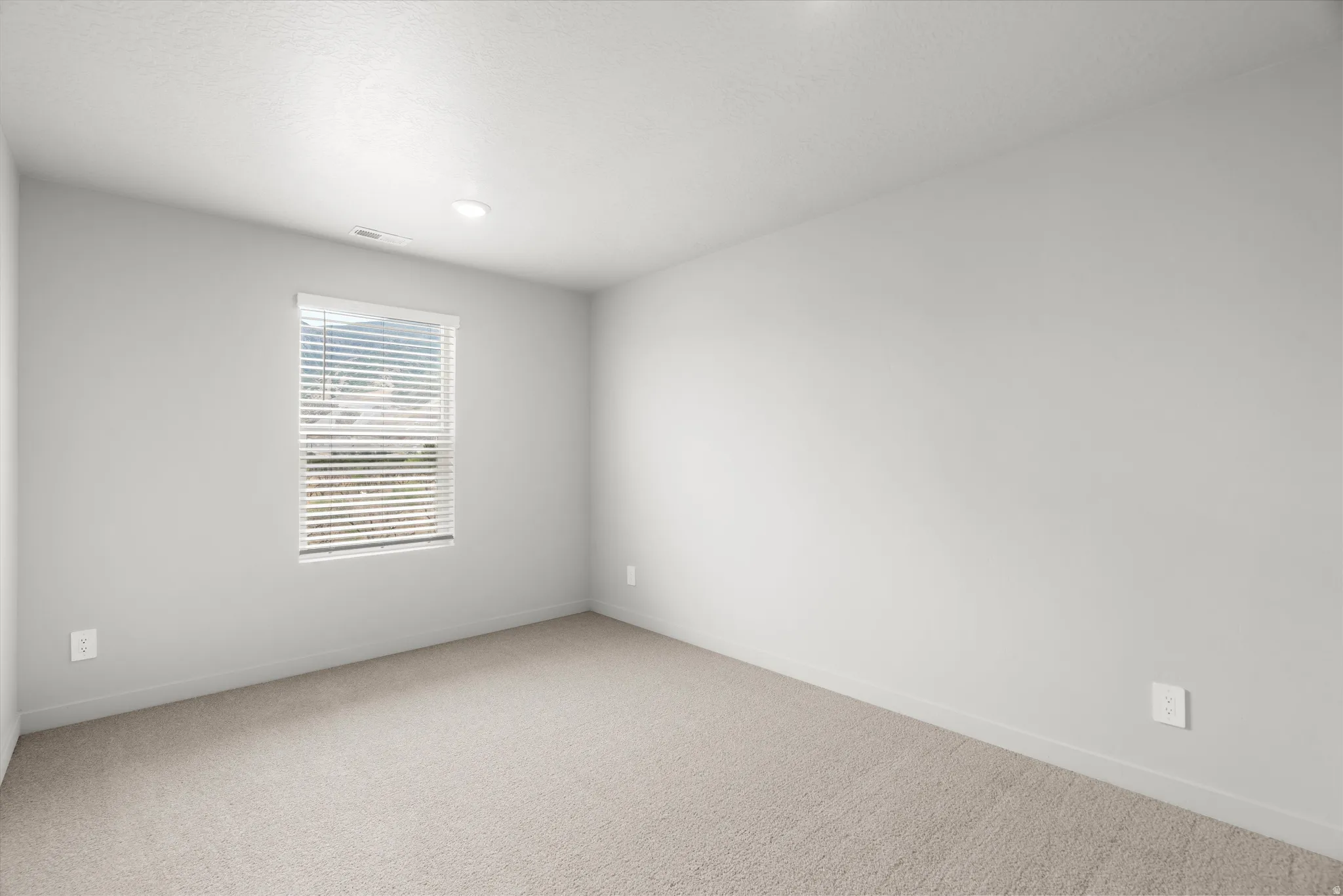 Room featuring neutral carpeting, a single window with horizontal blinds, and recessed lighting