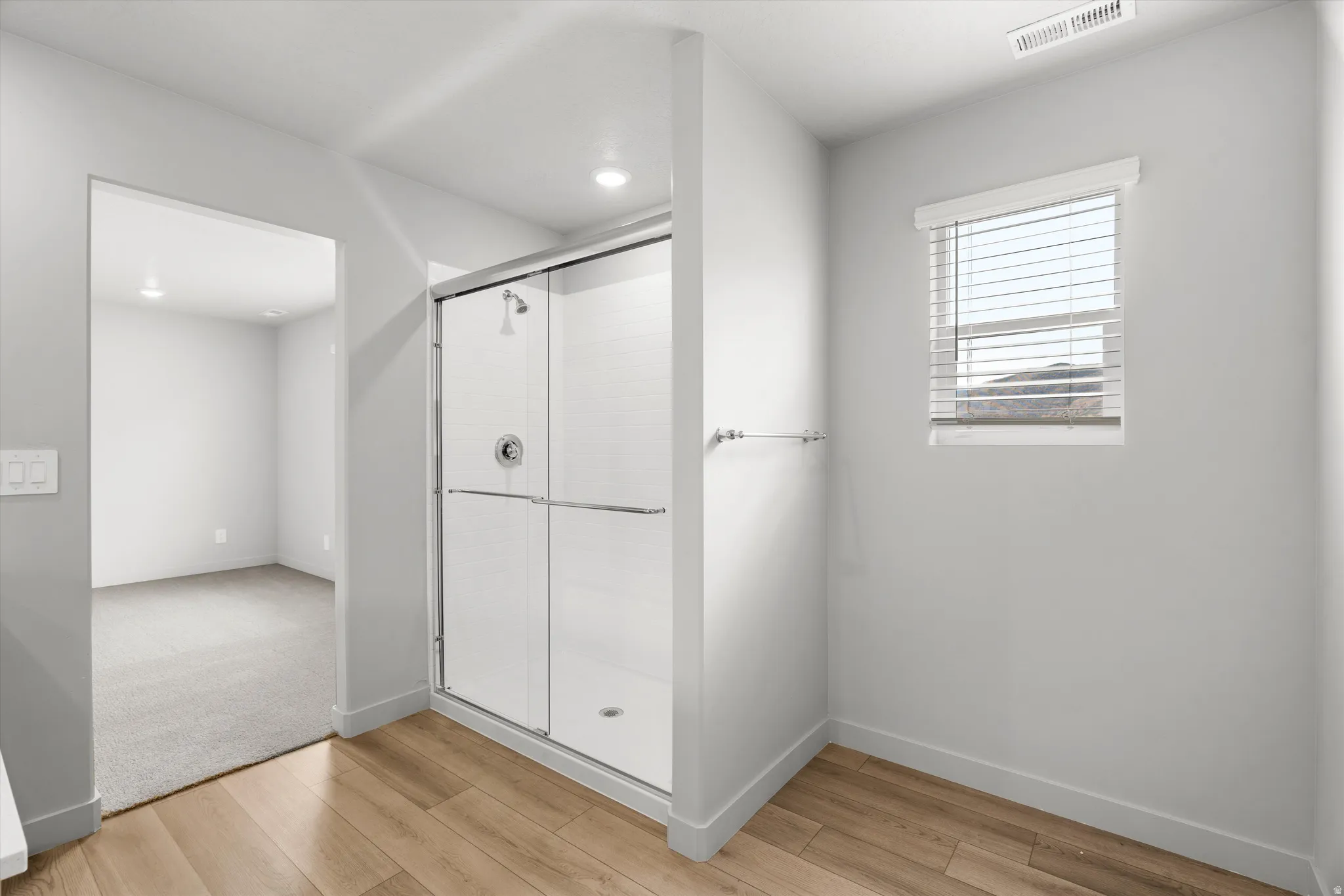 Enclosed shower with glass sliding doors and an integrated shower head