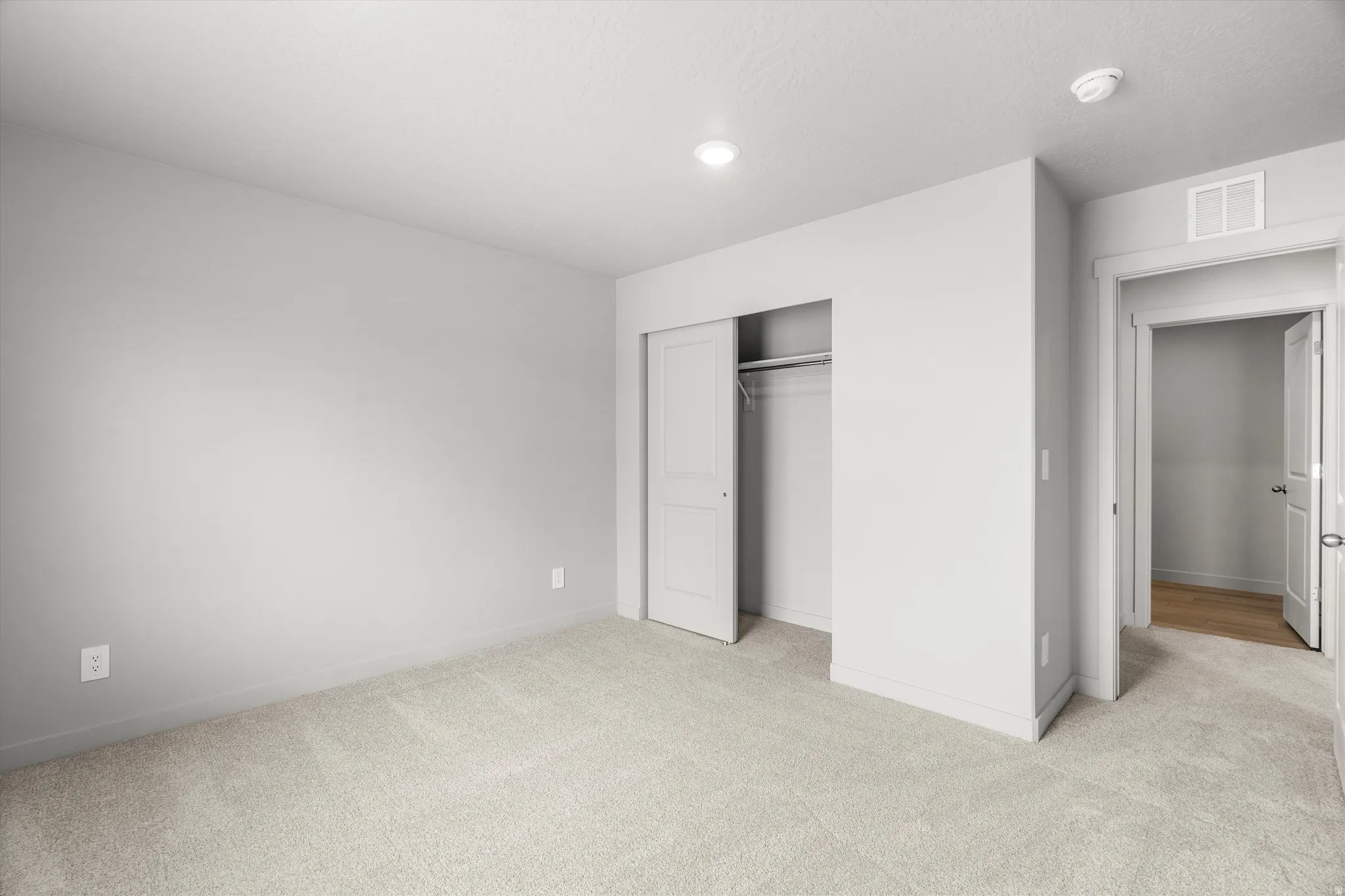 Carpeted interior room with light gray walls