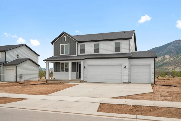 Contemporary two-story residence featuring light gray siding and dark gray vertical accents