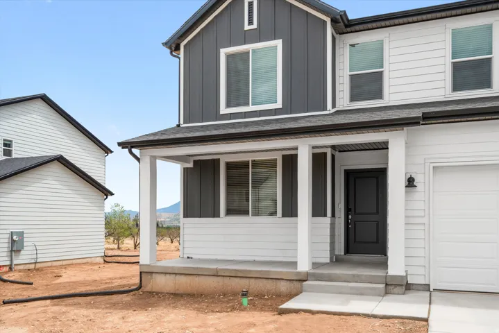 Contemporary two-story residence featuring a two-tone facade with dark gray board-and-batten and white horizontal siding