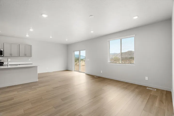Open-concept living space featuring wood-finish flooring, recessed lighting, and light gray walls