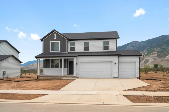 Two-story residence featuring a contemporary exterior with contrasting siding, a covered entry porch, and an attached three-car garage